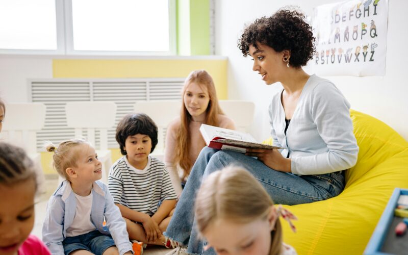 Children sitting with a teacher in a nursery classroom setting
