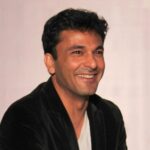 Portrait of Michelin-star chef Vikas Khanna smiling, wearing a professional chef's coat.