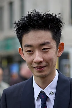 Professional snooker player Wu Yize in a black vest and white shirt, focused during a tournament match.